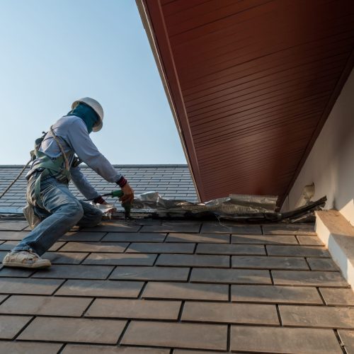 A roofing professional on a roof working