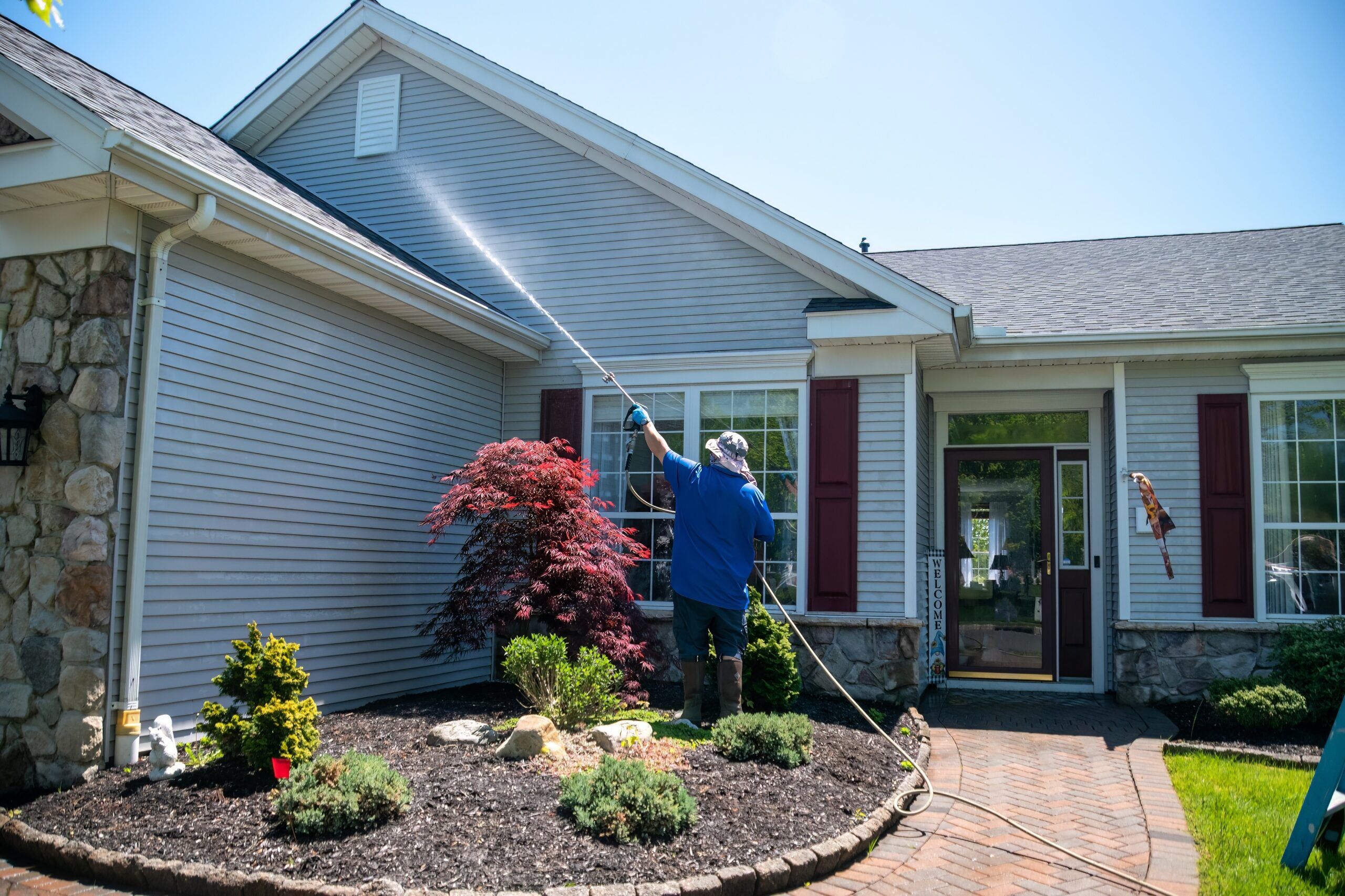 A man cleaning his home's siding