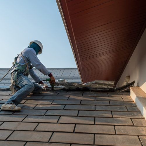 A roofing professional on a roof working